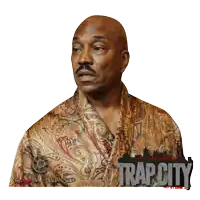a man wearing a paisley shirt with the word trap city on the bottom