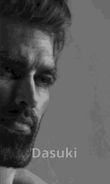 a black and white photo of a shirtless man with a beard and the name dasuki on his chest .