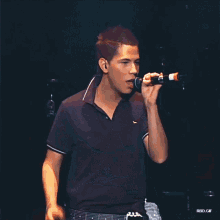 a man singing into a microphone with rbd.gif written on the bottom right