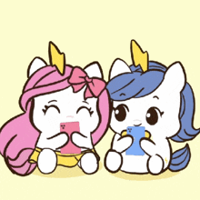 two unicorns are sitting next to each other and looking at their cell phones