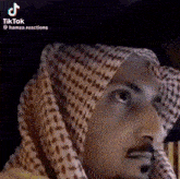 a close up of a man wearing a head scarf