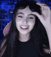 a woman wearing sunglasses is smiling in front of a shelf that says life
