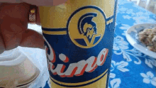 person holding a can of primo beer on a table