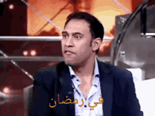 a man in a suit with arabic writing on the bottom