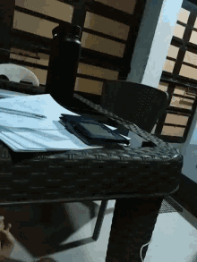a wicker chair with a tablet hanging from it
