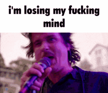 a man singing into a microphone with the words i 'm losing my fucking mind
