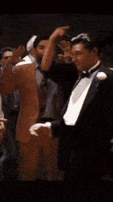 a man in a tuxedo and a woman in a dress are dancing
