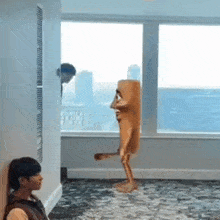 a man is standing in a room with a cartoon character standing in front of him .