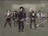 a group of people are standing on a stage playing guitars and singing .