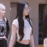 a girl with long black hair wearing glasses and a crop top