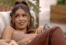 a woman with a tattoo on her arm is laying on a couch .