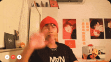 a man wearing a black shirt that says mvn waves his hand