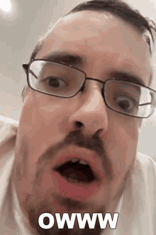 a man with glasses and a beard is making a funny face with the words owww written on the bottom
