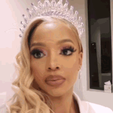 a close up of a woman wearing a tiara .