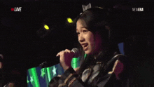 a girl singing into a microphone with the words live in the corner