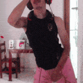 a man wearing headphones and a black tank top with a bull on the front is dancing