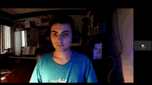 a man wearing headphones and a blue shirt with a crown on it