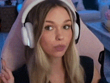 a woman wearing headphones and a microphone is sitting in a pink chair .