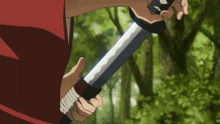 a person in a red shirt is holding a sword in their right hand