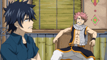 a man with a scarf around his neck sits next to another man with a scarf around his neck