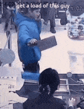 a man in a blue jacket is talking on a cell phone while holding a knife .