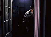 a man standing in a dark room talking on a phone
