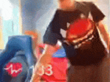 a blurry picture of a man wearing a black shirt with a red heart on it standing in a room .