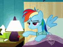 rainbow dash is laying in bed with a bandaged arm
