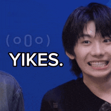 a young man smiles in front of a blue background with the words yikes
