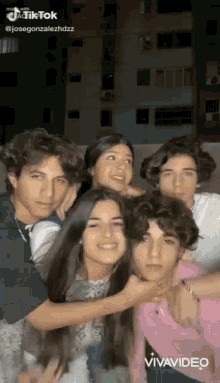 a group of young people are posing for a picture together and smiling .