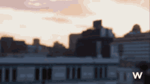a blurry picture of a city skyline with the letter w on the bottom right