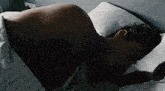 a man is sleeping in a bed with his back to the camera