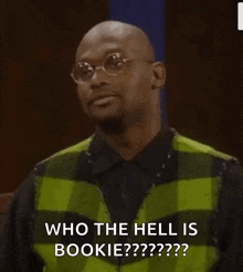 a man wearing glasses and a green vest says who the hell is bookie .