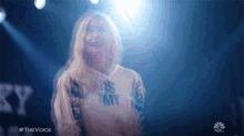 a woman is wearing a shirt that says ' nbc ' on it