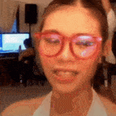 a close up of a woman wearing pink glasses and a white shirt