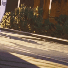 a person riding a skateboard down a street with a fence in the background