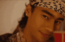a close up of a man wearing a headband with a leopard print