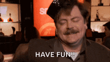 a man with a mustache is sitting at a bar and saying have fun