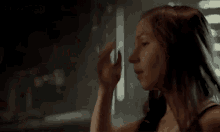 two women are kissing in a dark room .
