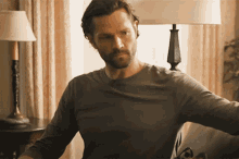 a man with a beard is sitting in a living room