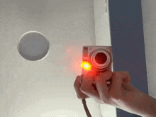 a person taking a picture with a camera that has a red light on it