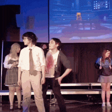 a group of people are standing on a stage in front of a large screen that says ' netflix ' on it