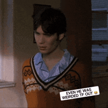 a man wearing a sweater with a sticker that says even he was weirded tf out