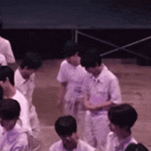 a group of young men in white shirts are standing in a line .