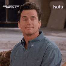 a man is sitting on a couch with his eyes closed in front of a sign that says mid century modern