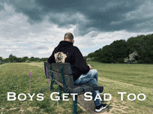 a man sits on a park bench with the words boys get sad too