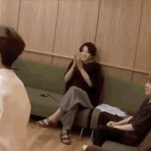 a group of people are sitting on couches in a room .