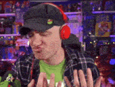 a man wearing headphones and a hat makes a funny face