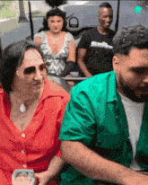 a man in a green shirt is sitting next to a woman in a red top