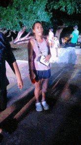 a woman wearing a pink tank top that says ' victoria 's secret ' on the front